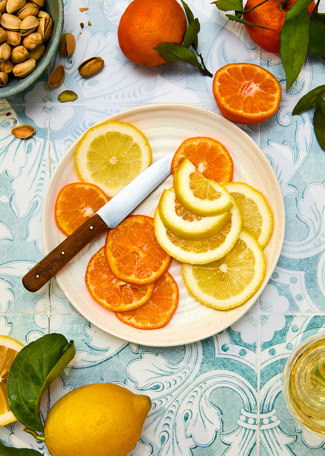 Still life food photography of juicy sliced oranges and lemons. Shot on a tiled backdrop. Images by London based food and tableware photographer Lol Johnson. Food styling by Iona Blackshaw. Props styling by Nuala Sharkey.