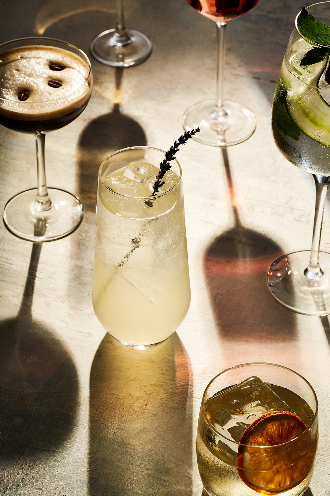 An selection of summer drinks on a table bathed in early evening sun for Do Deli @ Hilton. Photography by London based food and drink and lifestyle photographer Lol Johnson. Drink prep and styling by Iona Blacksmith.