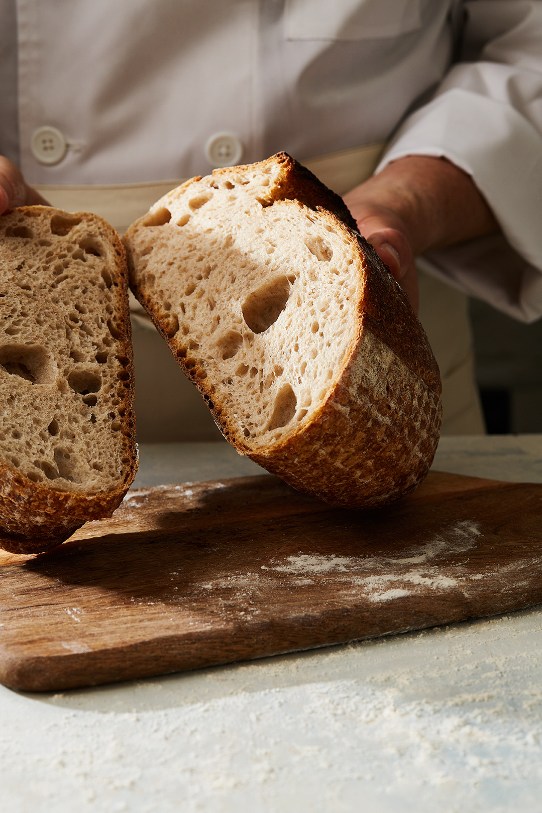 Baker holding bread for Hilton in-house deli brand Do Deli. Photography by Lol Johnson. Food Prep and styling by Iona Blackshaw. Recipe development by Jane Alty.