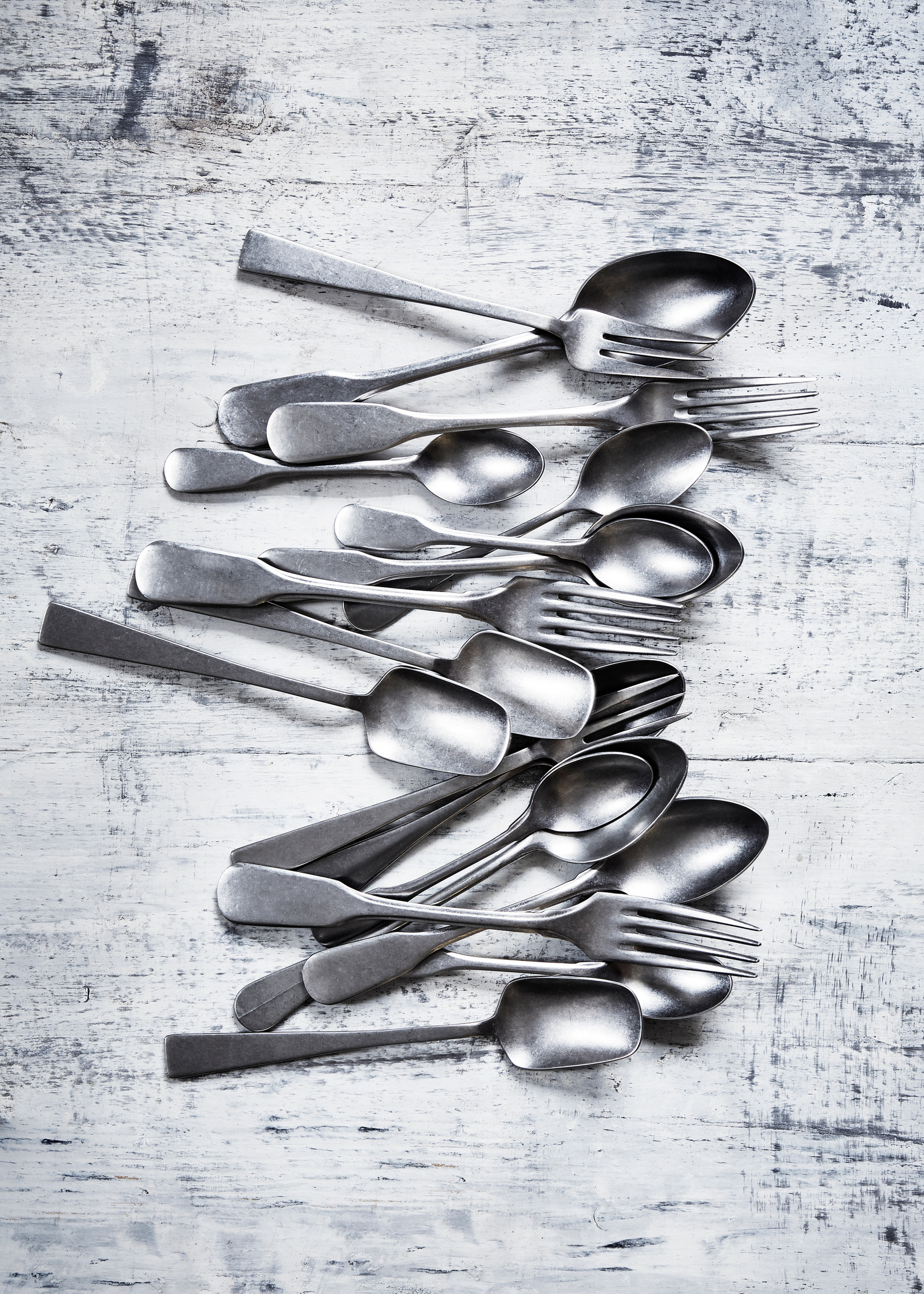 Still life imagery of classic tarnished cutlery shot against a distressed wooden surface from Topham Street props house. Shot for branding agency Seeing Things Creative by London based food and tableware photographer Lol Johnson.