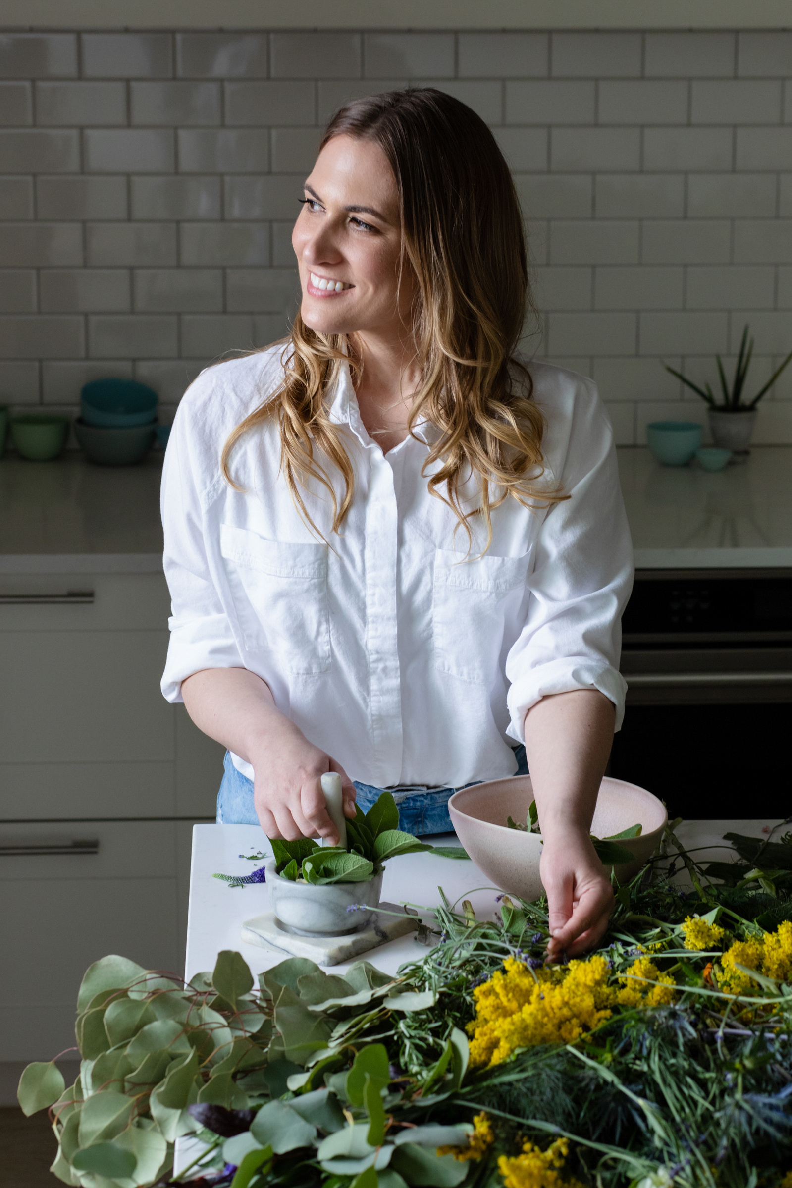 Portrait of a professional naturopath woman cutting eucalyptus and other plants.