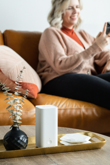 Woman on couch using Vilo mesh system in her home. 