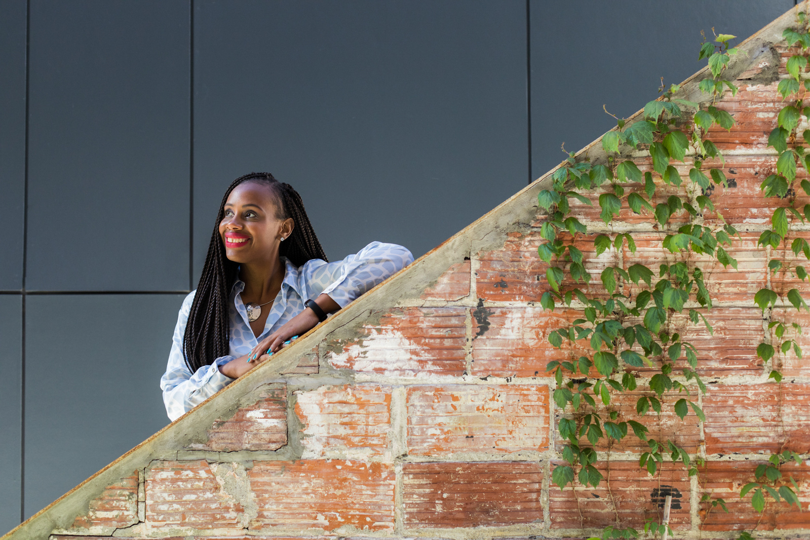 A smiling woman in front a brick wall. 