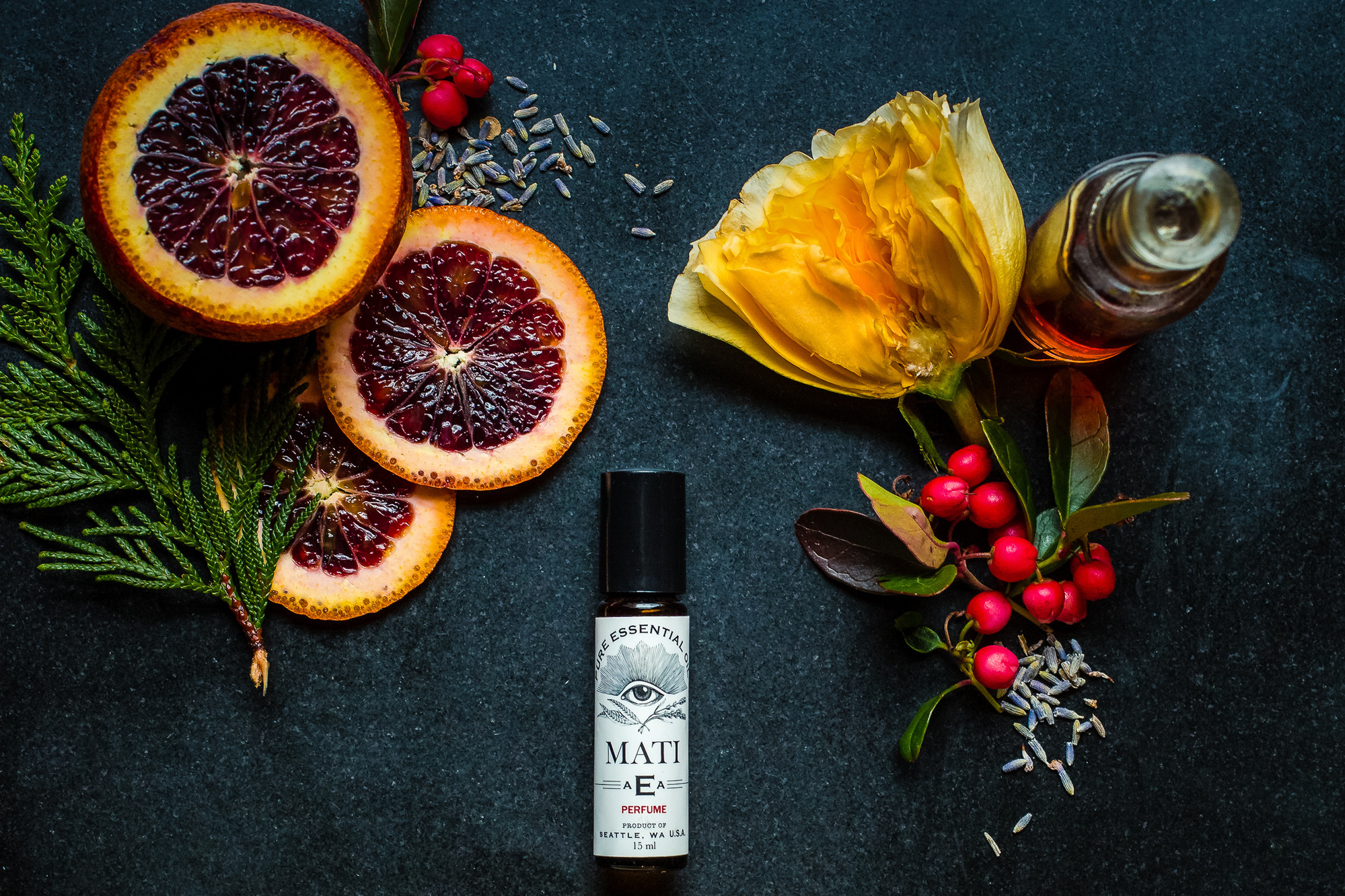 Dark layflat branding photography of perfume and ingredients.