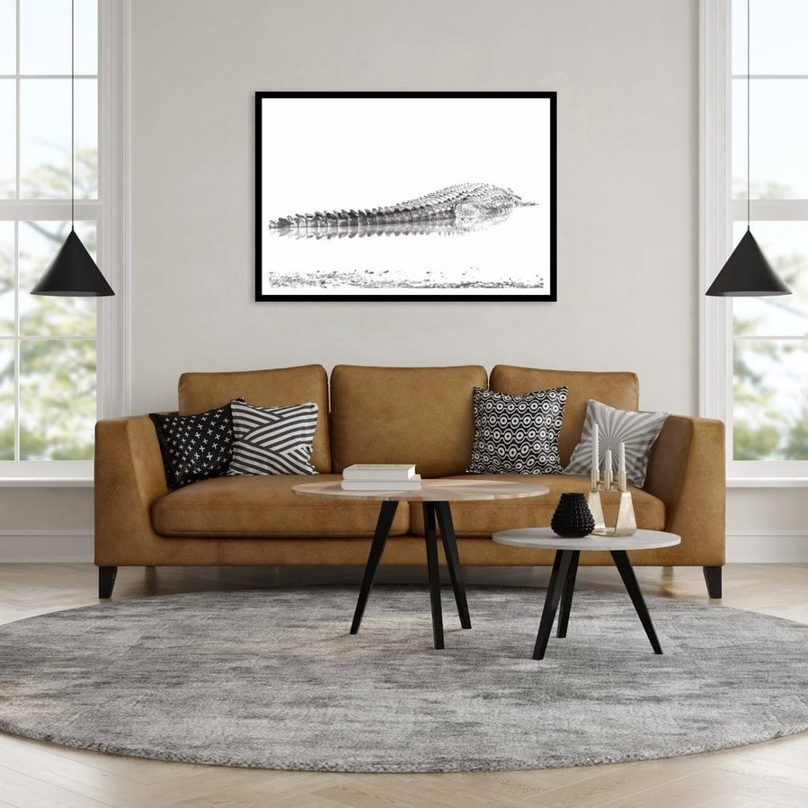 Overexposed black and white photograph of a Nile crocodile resting at the edge of a body of water. The dramatic lighting and minimal composition highlight the intricate textures and patterns of the crocodile’s scaly back creating a fine art wildlife image