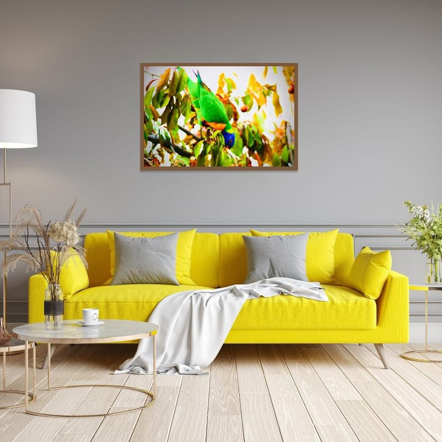 Rainbow lorikeet hanging upside down on a tree branch, surrounded by golden leaves and sunlit fruit. The bird’s vivid green, blue, and orange feathers contrast against the warm autumn tones, capturing a playful moment in nature in walnut frame.