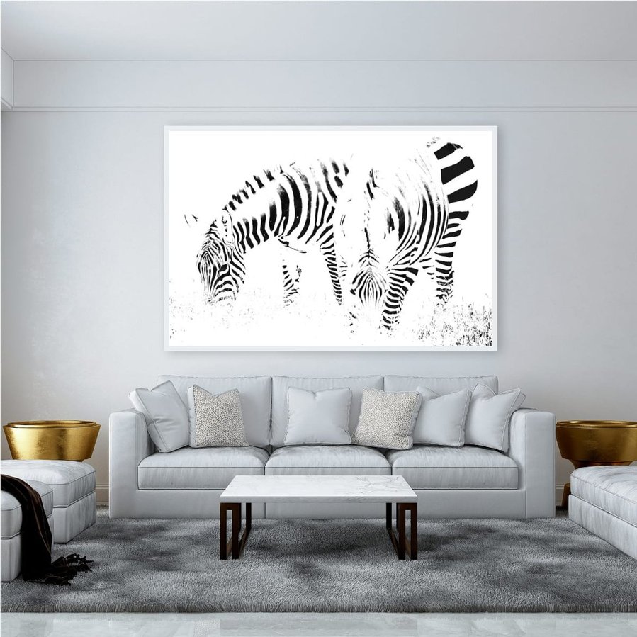 High-key black and white zebra photograph capturing two zebras grazing in perfect symmetry. A minimalist wildlife portrait focused on abstract patterns, contrast, and stillness.