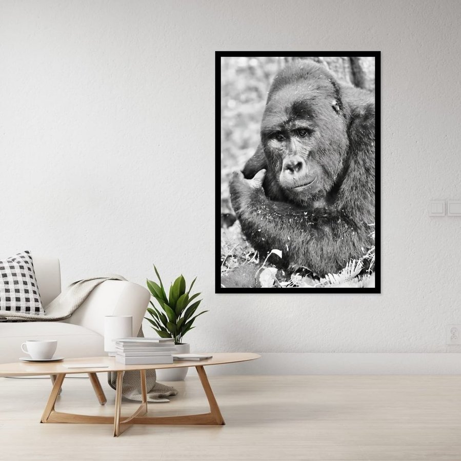Black and white wildlife portrait of a mountain gorilla caught in a quiet moment of reflection. His soft gaze and relaxed posture evoke a sense of calm, emotional depth, and connection in this fine art photograph.
