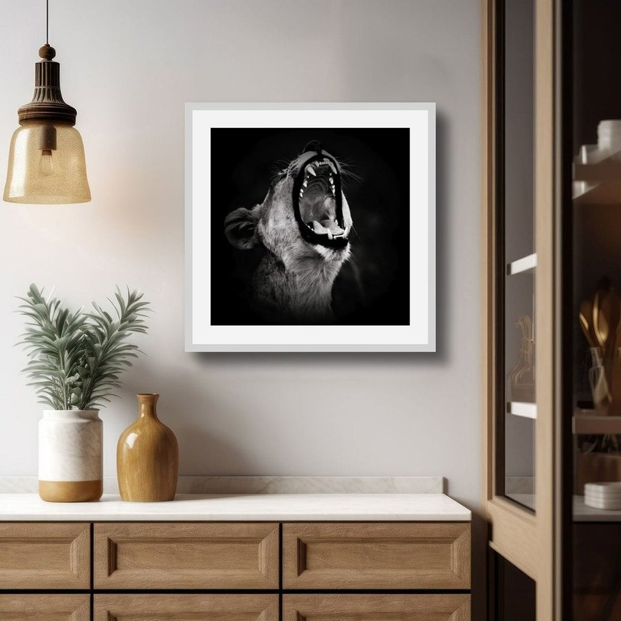 Powerful black and white side-profile photograph of a lioness mid-roar. Captured against a dark backdrop, this fine art wildlife image highlights her muscular form, fierce expression, and primal energy—an emotive portrait of strength and wild beauty.