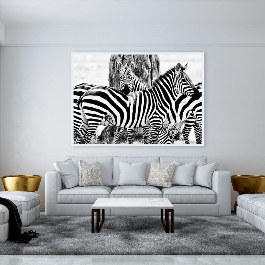 Black and white fine art photograph of zebras in close formation, with one resting its head across another’s back. Striking patterns, high contrast, and emotional connection captured in a timeless wildlife composition.