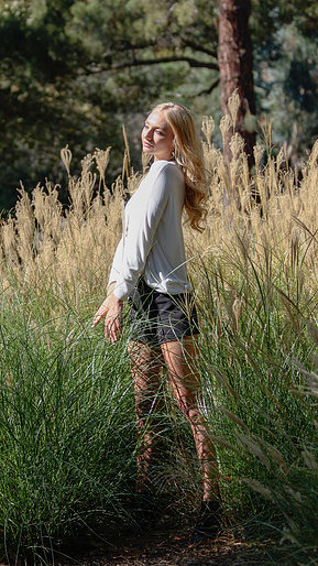 A woman posing at a park, casual portrait photography. 