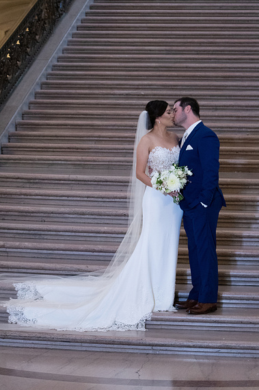Newly wed couple kissing on stairs. 