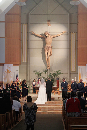 Catholic Church wedding, couple posing on the alter. 