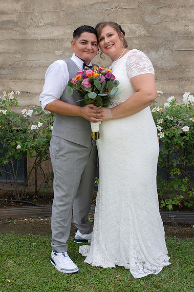 Newly wed LGBTQ couple posing together. 