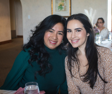 Mother and daughter posing next to each other. 