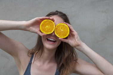 A fun pose, holding oranges over her eyes. 
