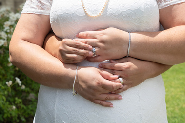 Newly wed couple embracing showing their rings. 
