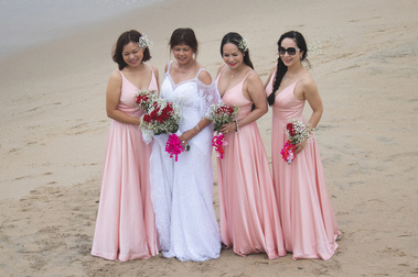 Bride and brides maid posing on the beach. 