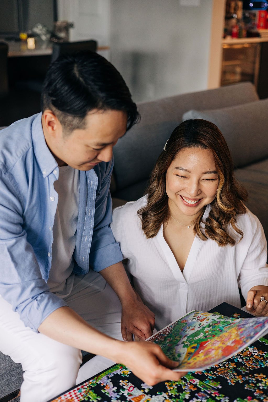 documentary style engagement photoshoot at home in the philadelphia suburbs couple doing puzzles