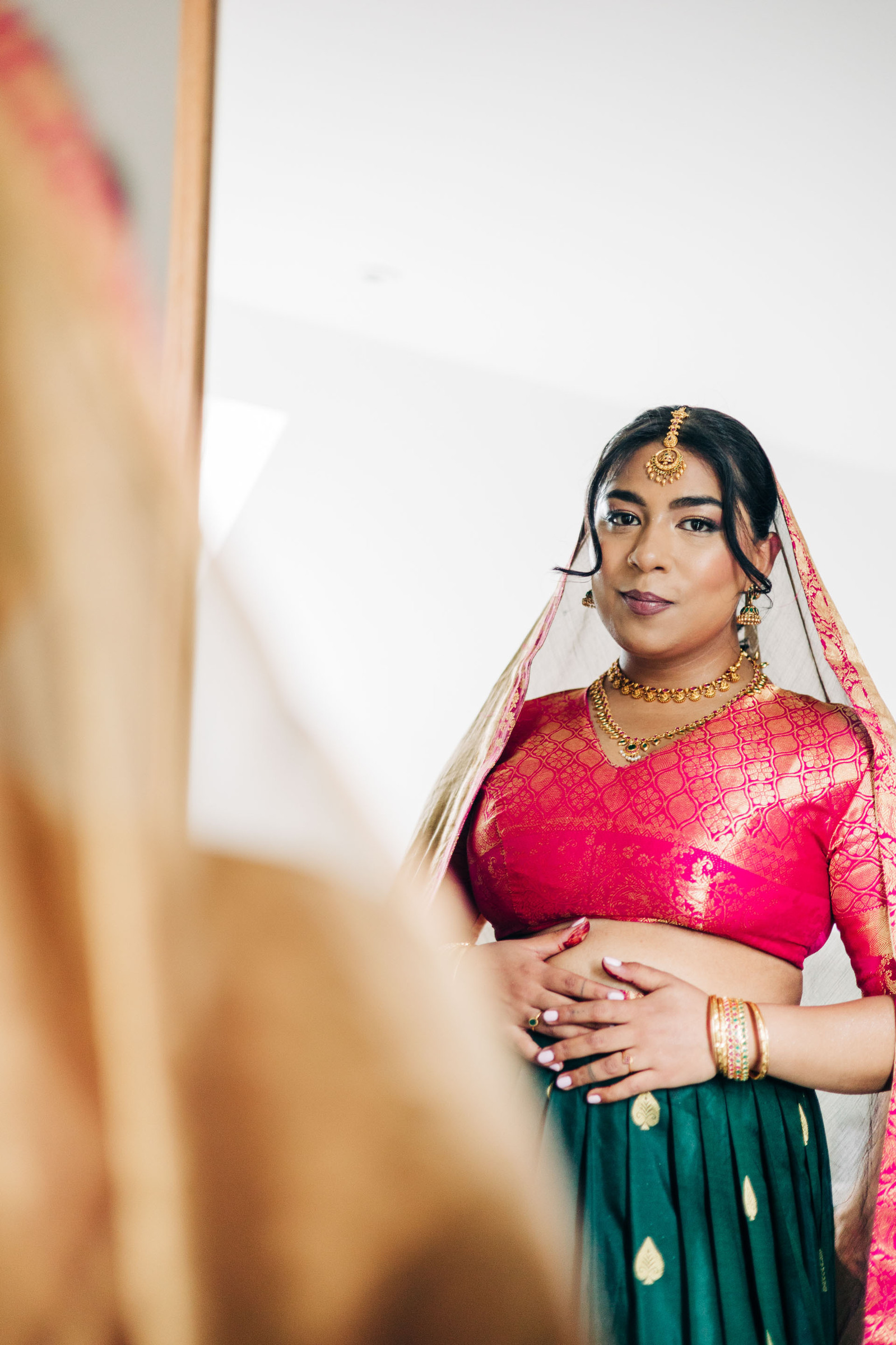 Indian bride wedding hot pink and green sari getting ready before ceremony at London Wedding