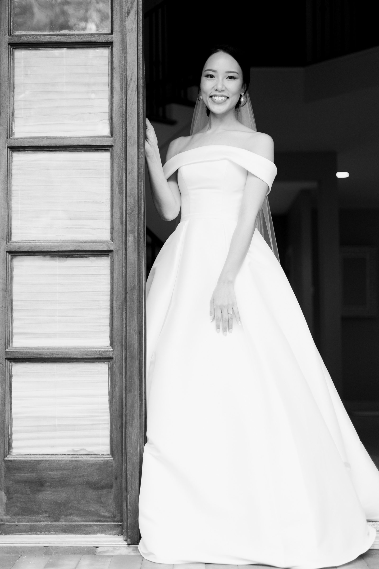 black and white photo of bride standing in doorway on her way to her wedding ceremony