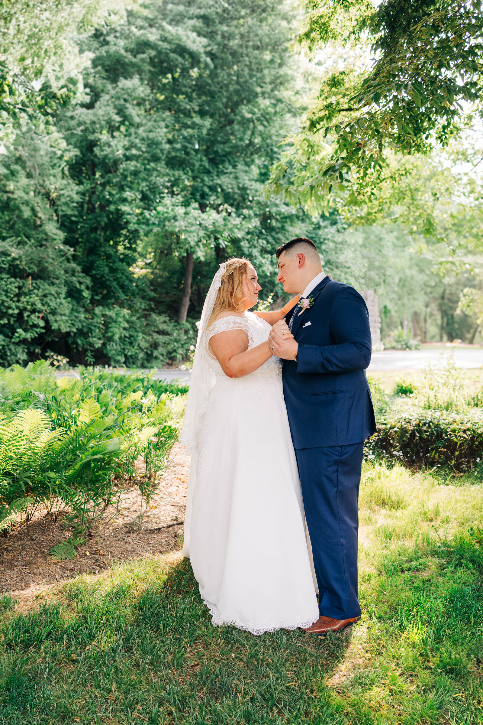 wedding portrait of bride and groom in warm sunlight outside during garden wedding 