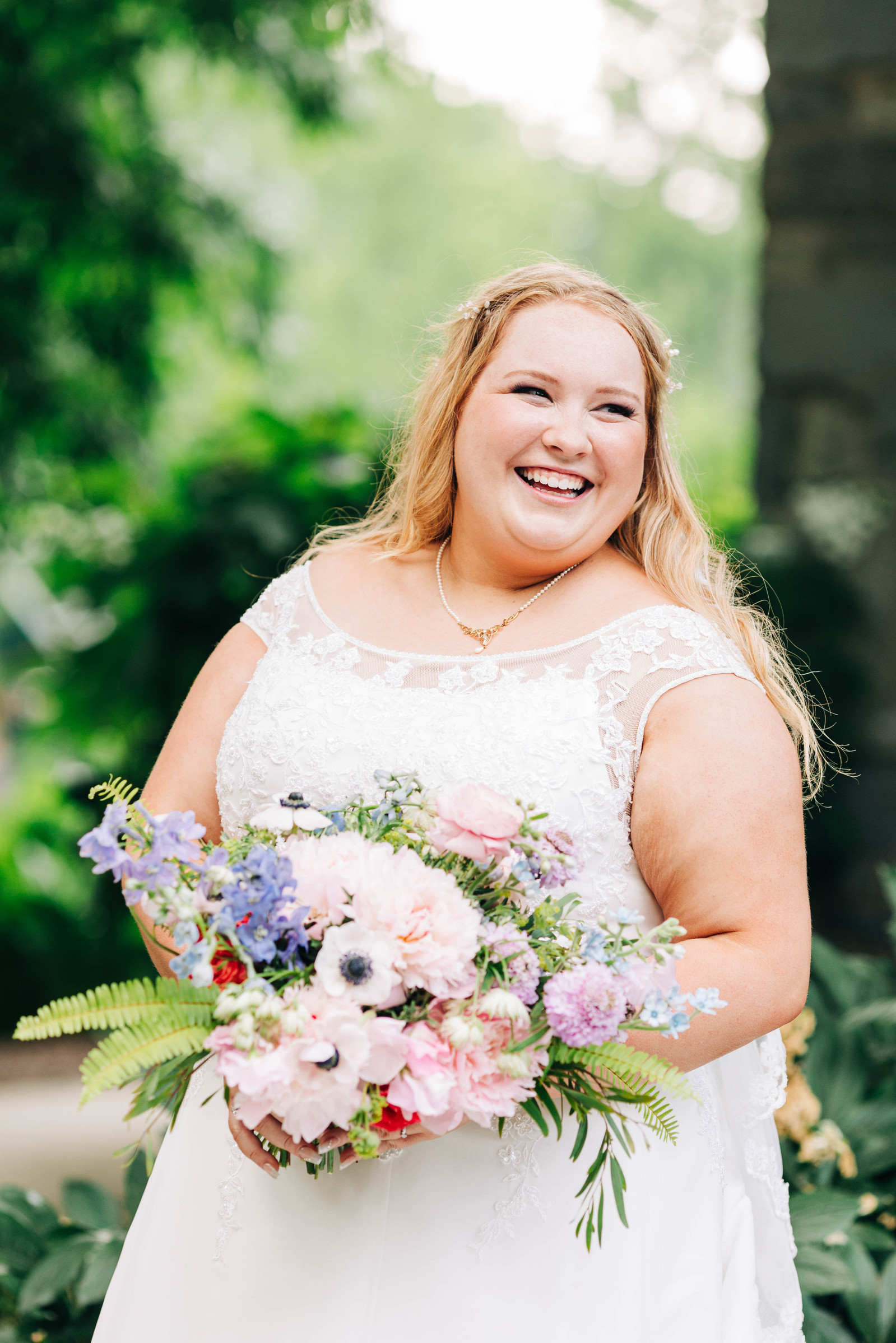bride with pastel floral bouquet outdoors during golden hour