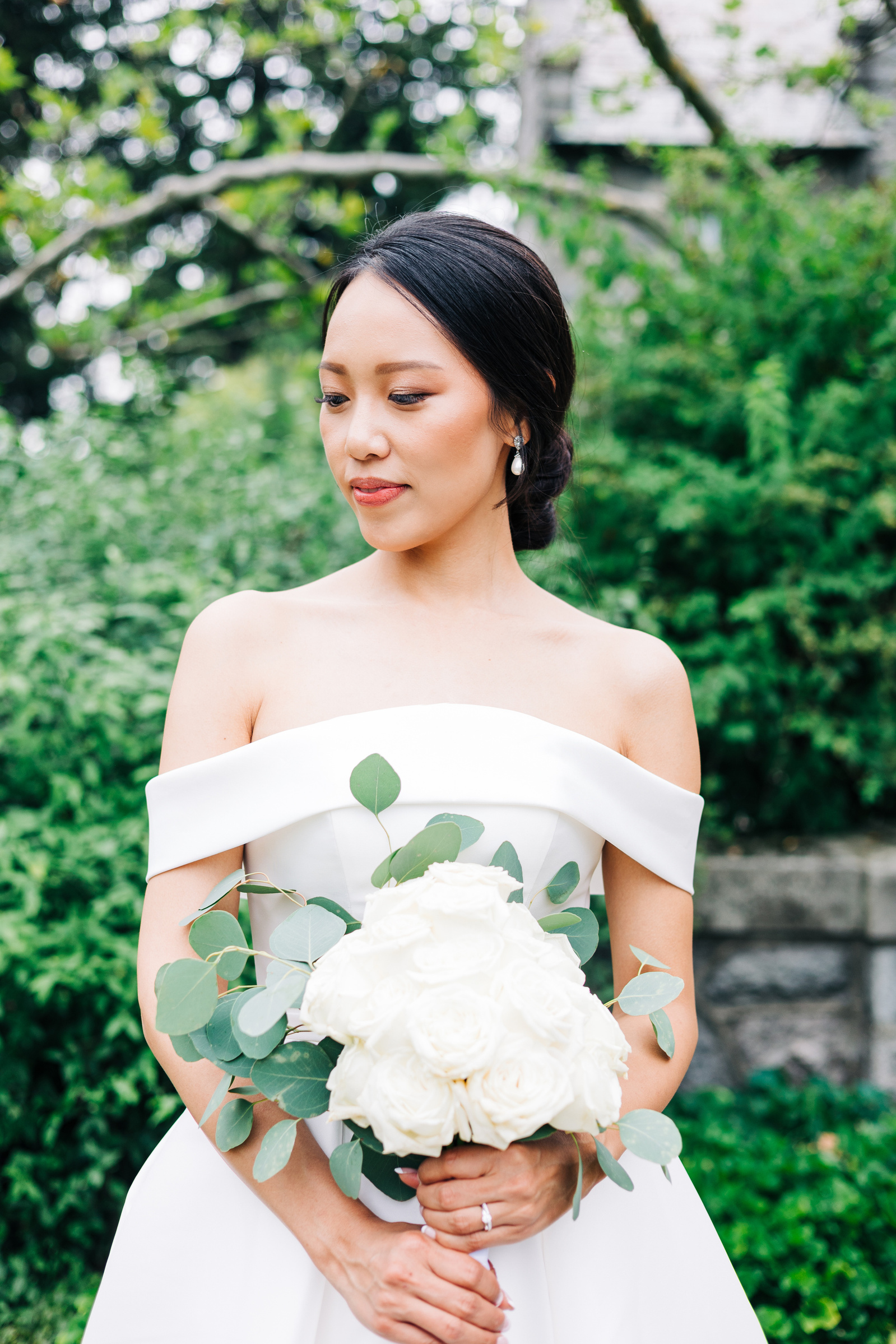 bridal portrait in natural light with greenery and bride holding bouquet 