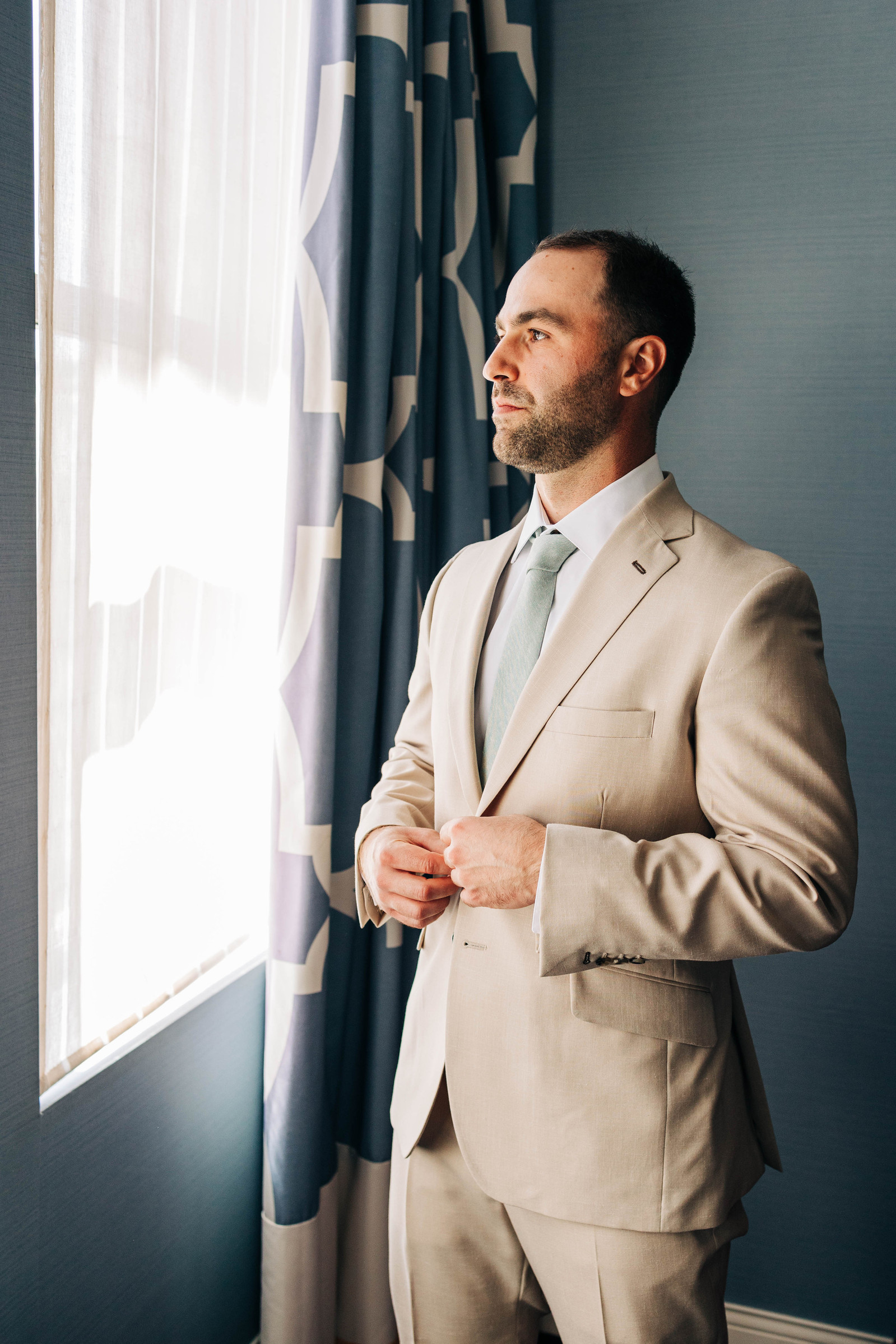 portrait of groom getting ready at hotel monaco philadelphia 