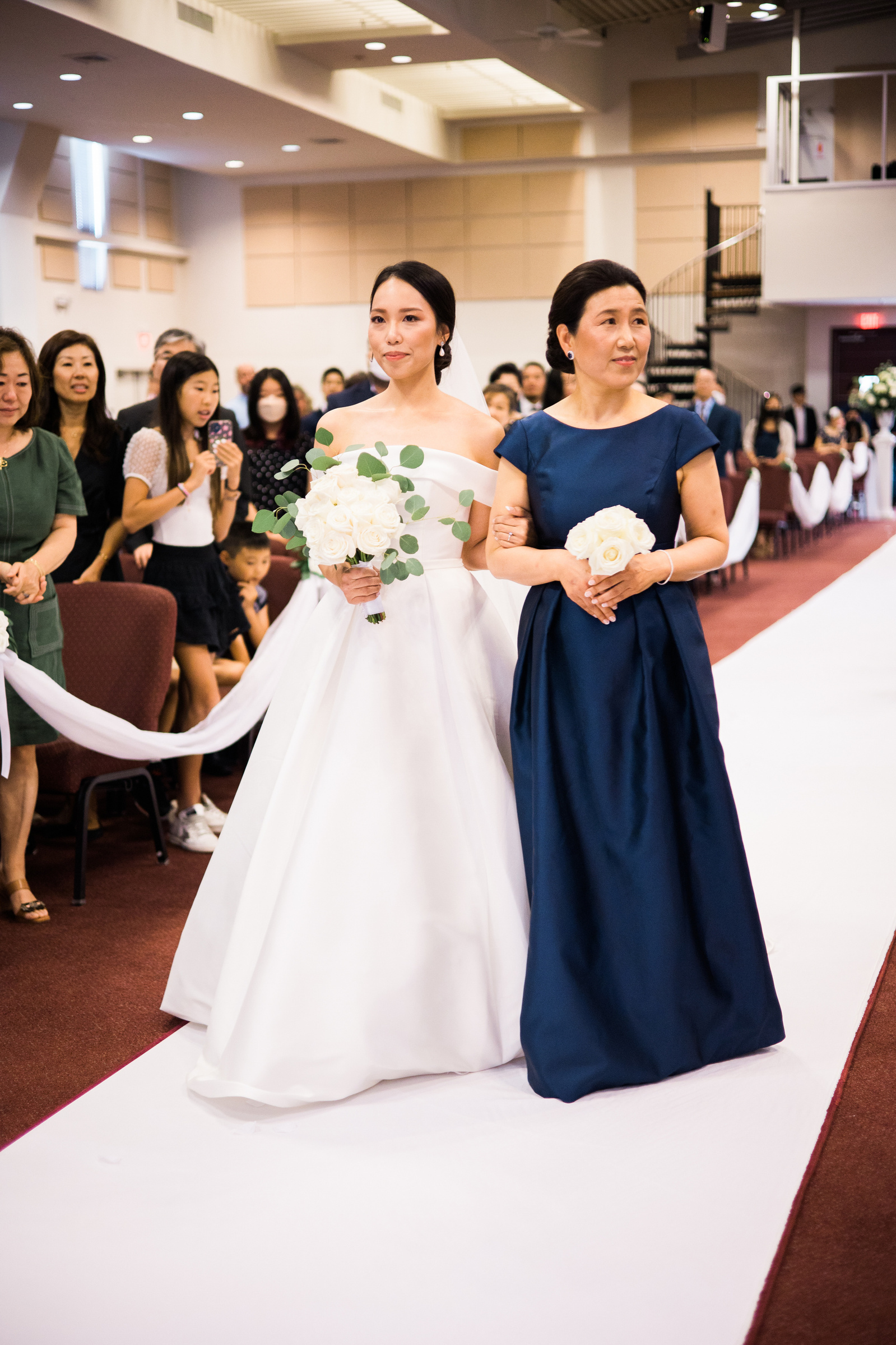 bride walks down the aisle with her mom