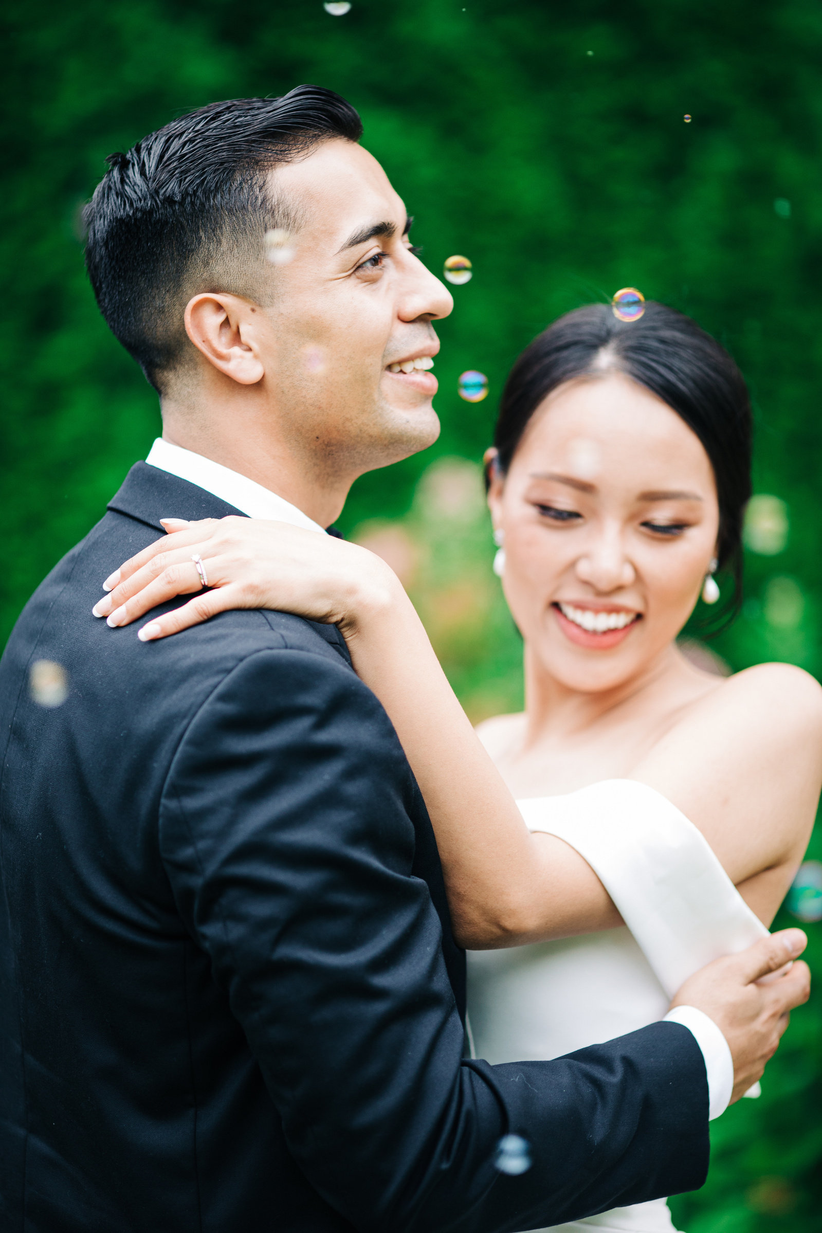 close up of bride and groom hugging and dancing with bubbles around them