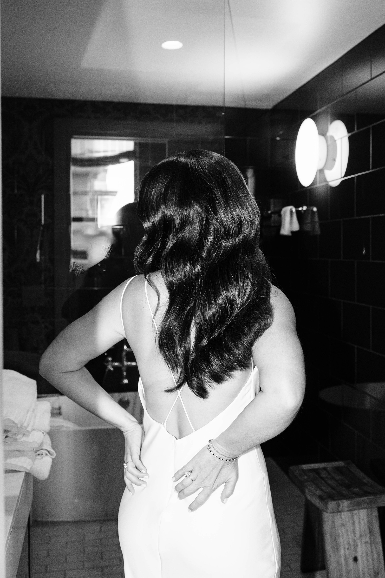 black and white flash photo of bride getting ready in bathroom at hotel monaco in philadelphia