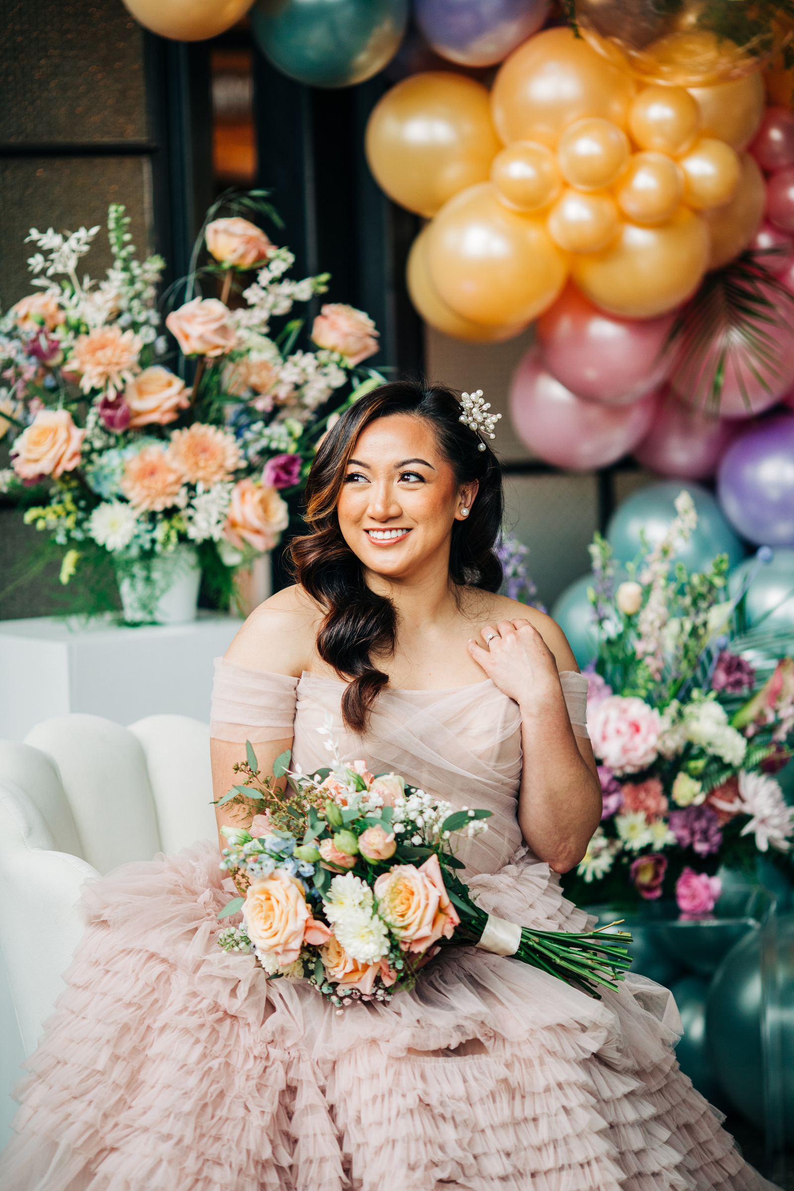 wedding portrait of bride in pink pastel dress with colorful flowers and balloons