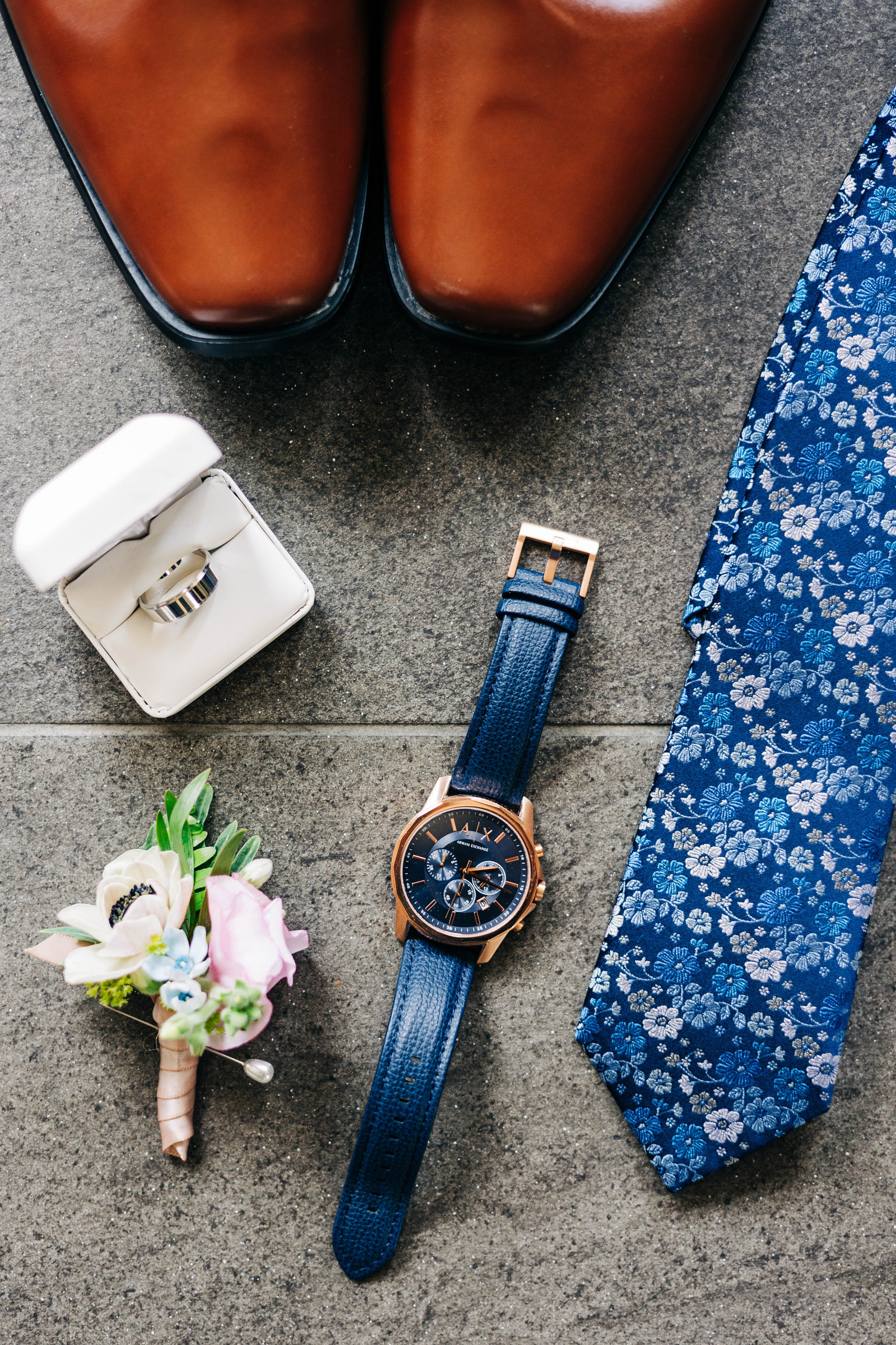 lay flat of groom details on wedding day featuring navy blue colors and pastel florals