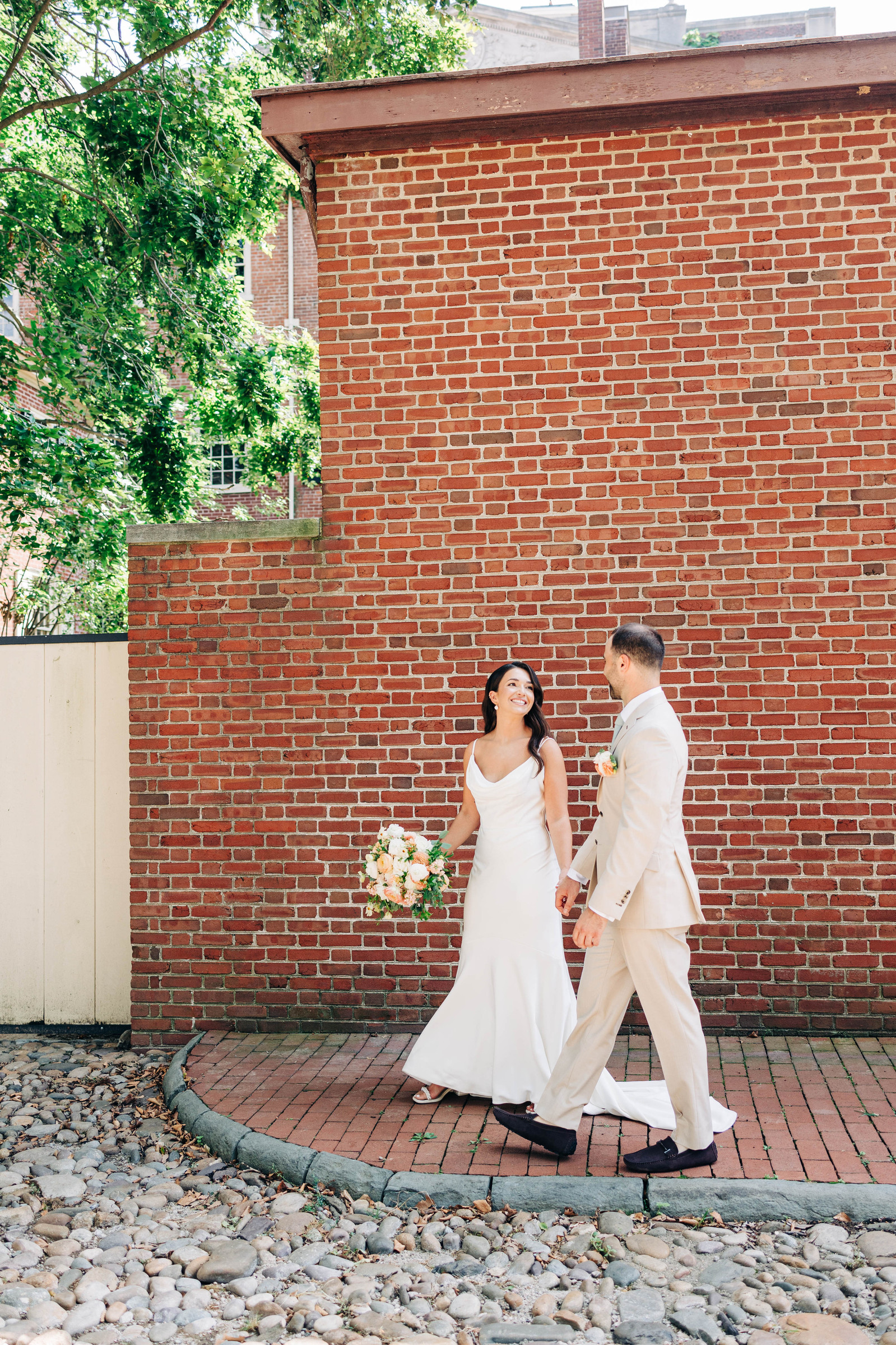 bride and groom walking in old city philadelphia on their wedding day candid wedding photography