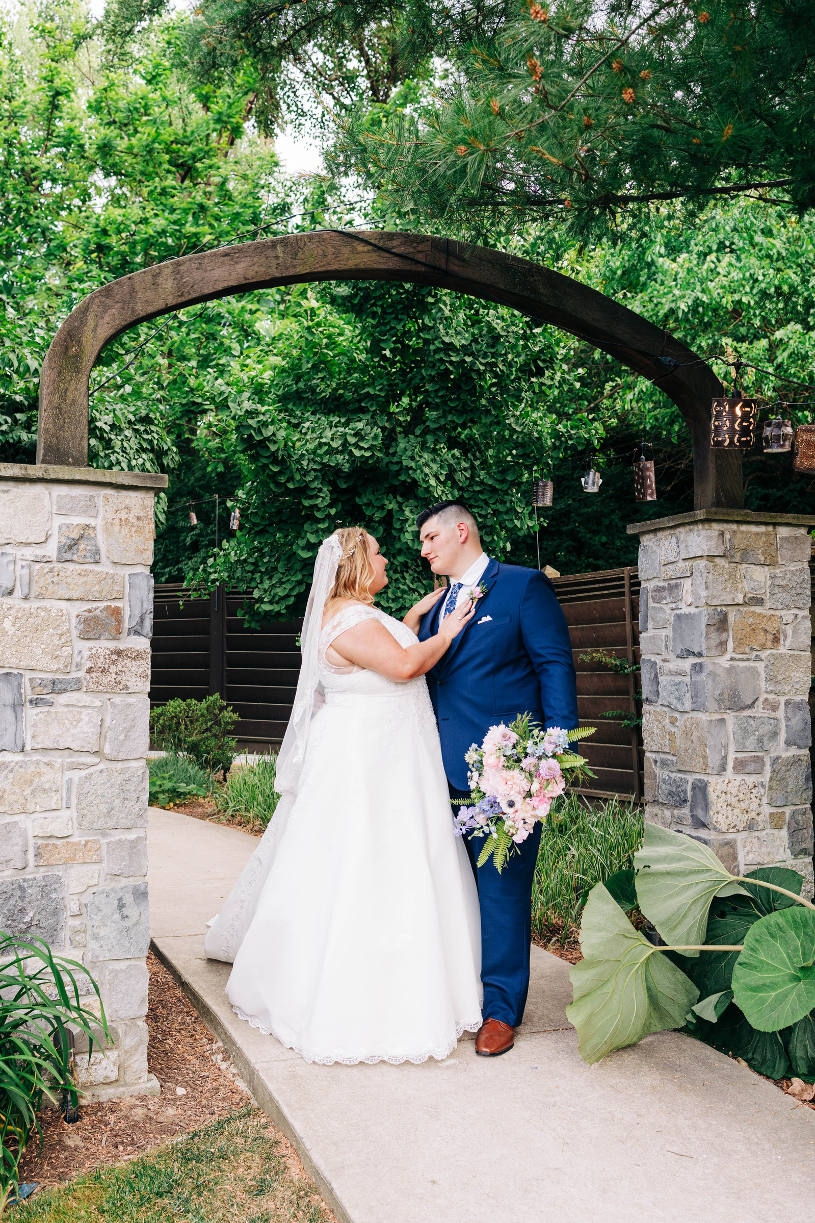 bride and groom outside in the gardens during their late spring early summer wedding at the farmhouse at people's light theater in malvern pennsylvania