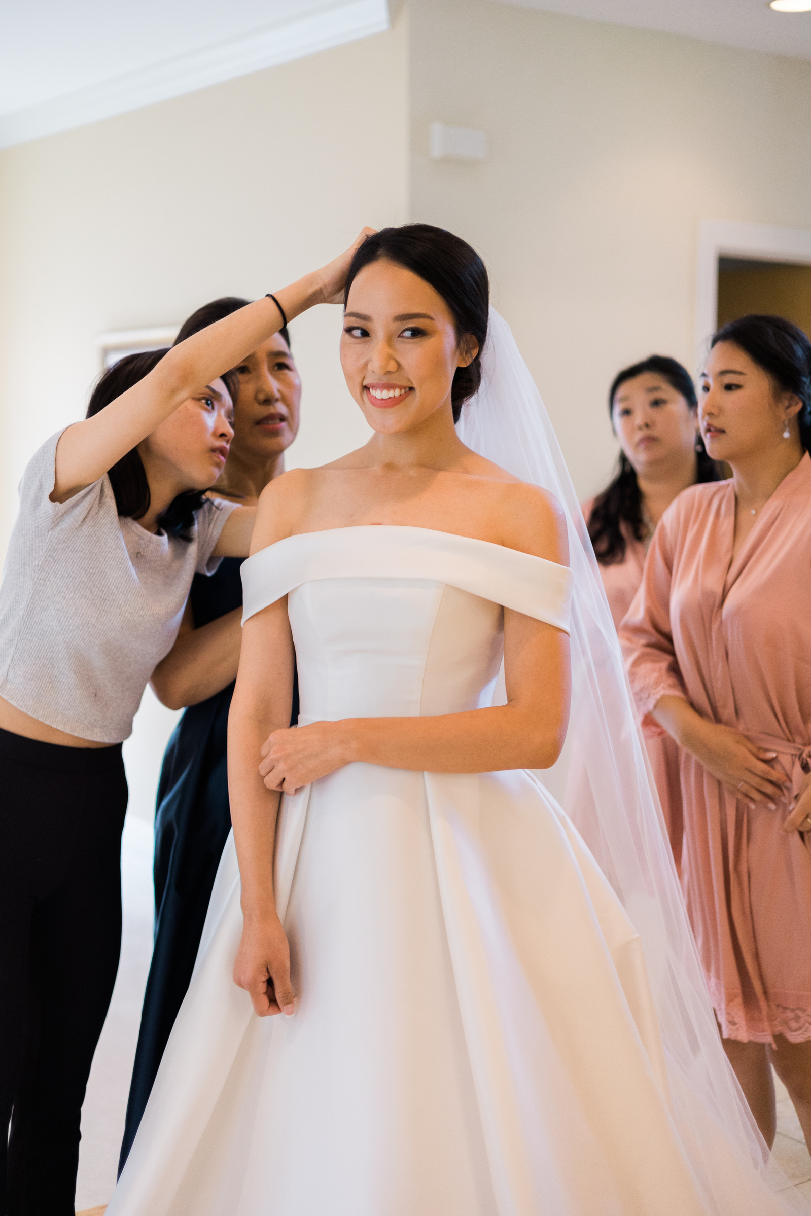 bride's family helping her put on her veil for her wedding