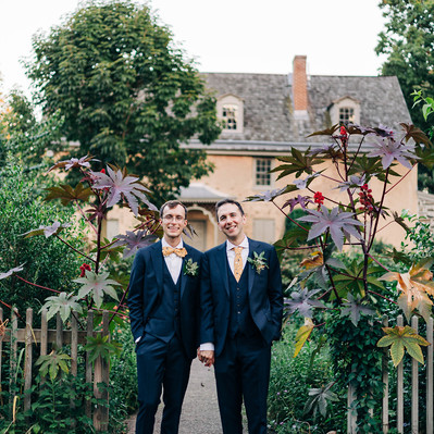 Two grooms holding hands and smiling on their wedding day at Bartram's Garden Wedding Venue in Philadelphia by LGBTQ Wedding Photographer Becca Haydu 