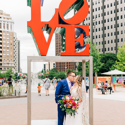 Bride and groom kissing under the famous Philadelphia LOVE statue at Love Park in Center City Philadelphia