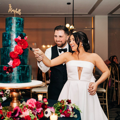 Bride and groom cutting a colorful wedding cake during their reception at The Lucy by Cescaphe on Broad Street in Center City Philadelphia