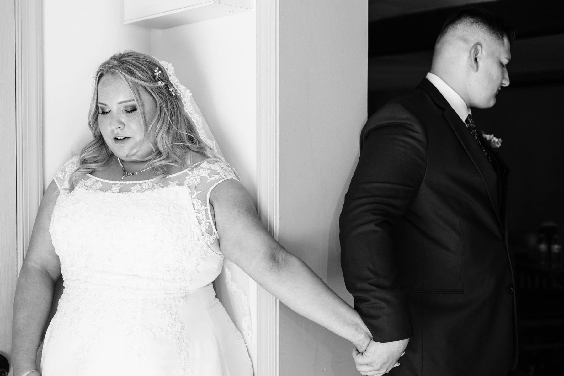 black and white photo of bride and groom first prayer or first touch before wedding ceremony