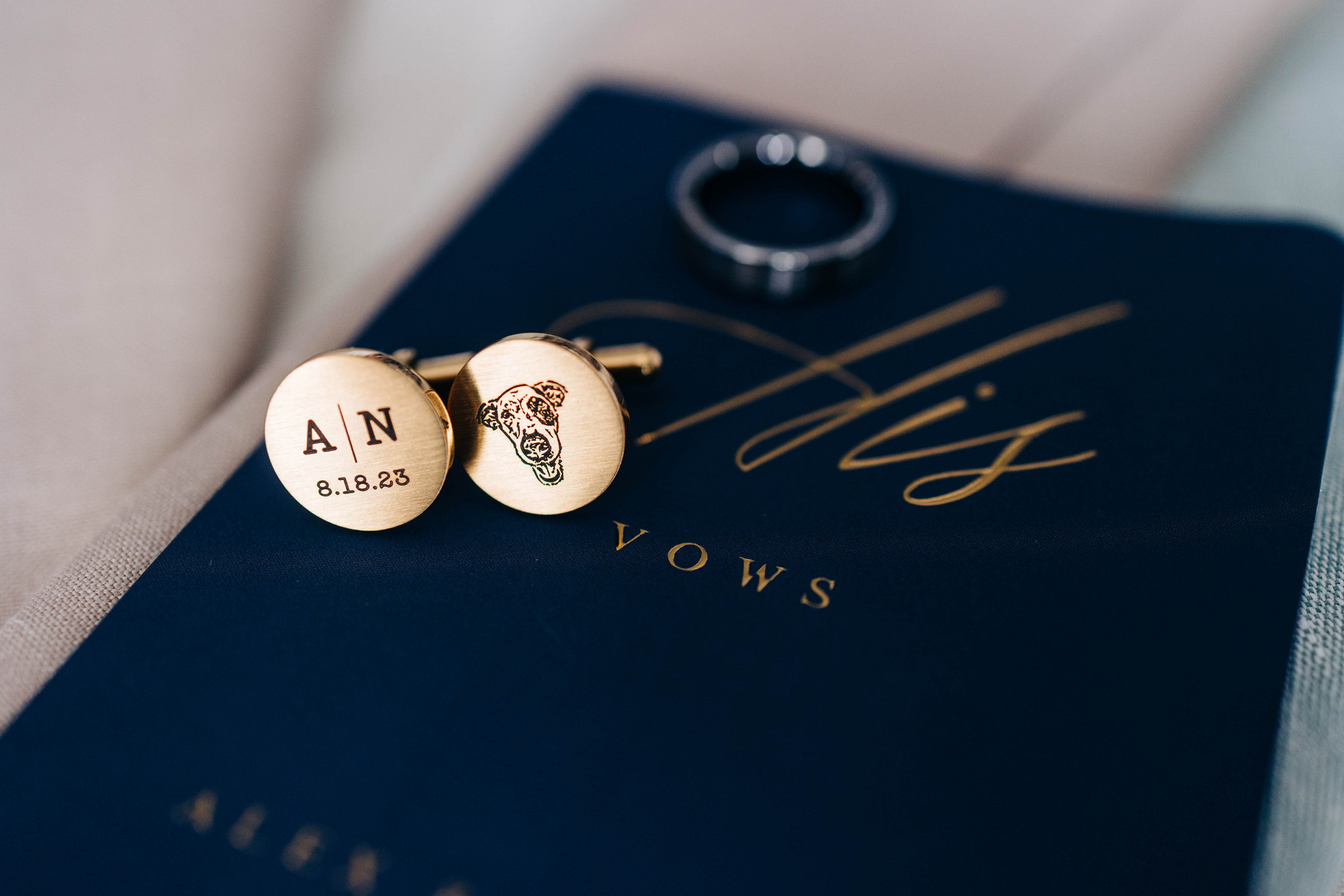groom's wedding details of custom cufflinks and vow book