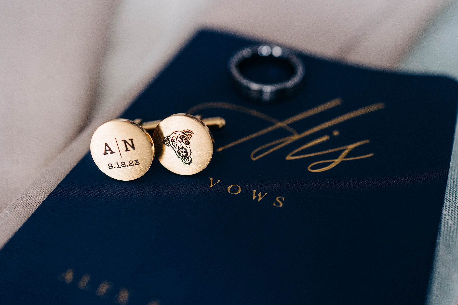 groom's wedding details of custom cufflinks and vow book