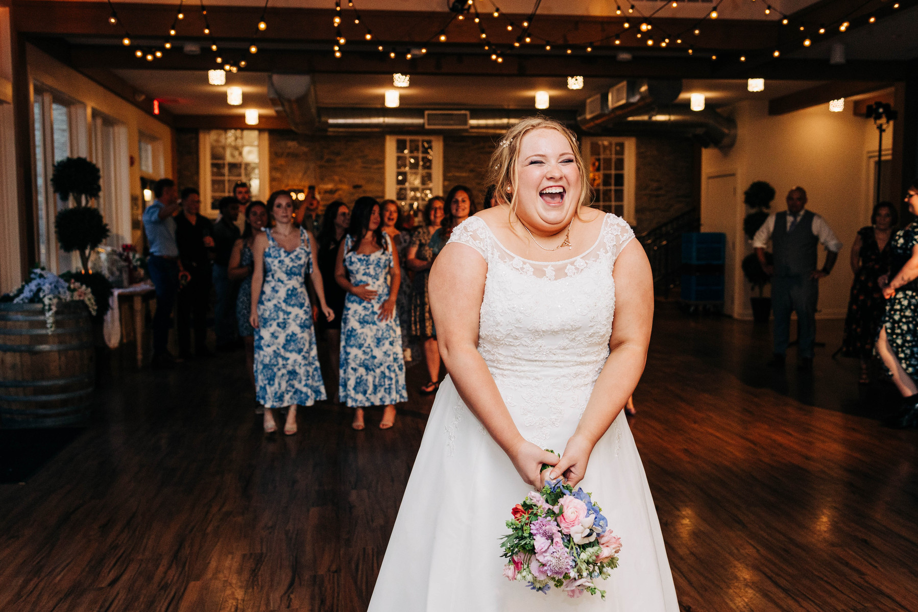 bride tossing bouquet during wedding reception 