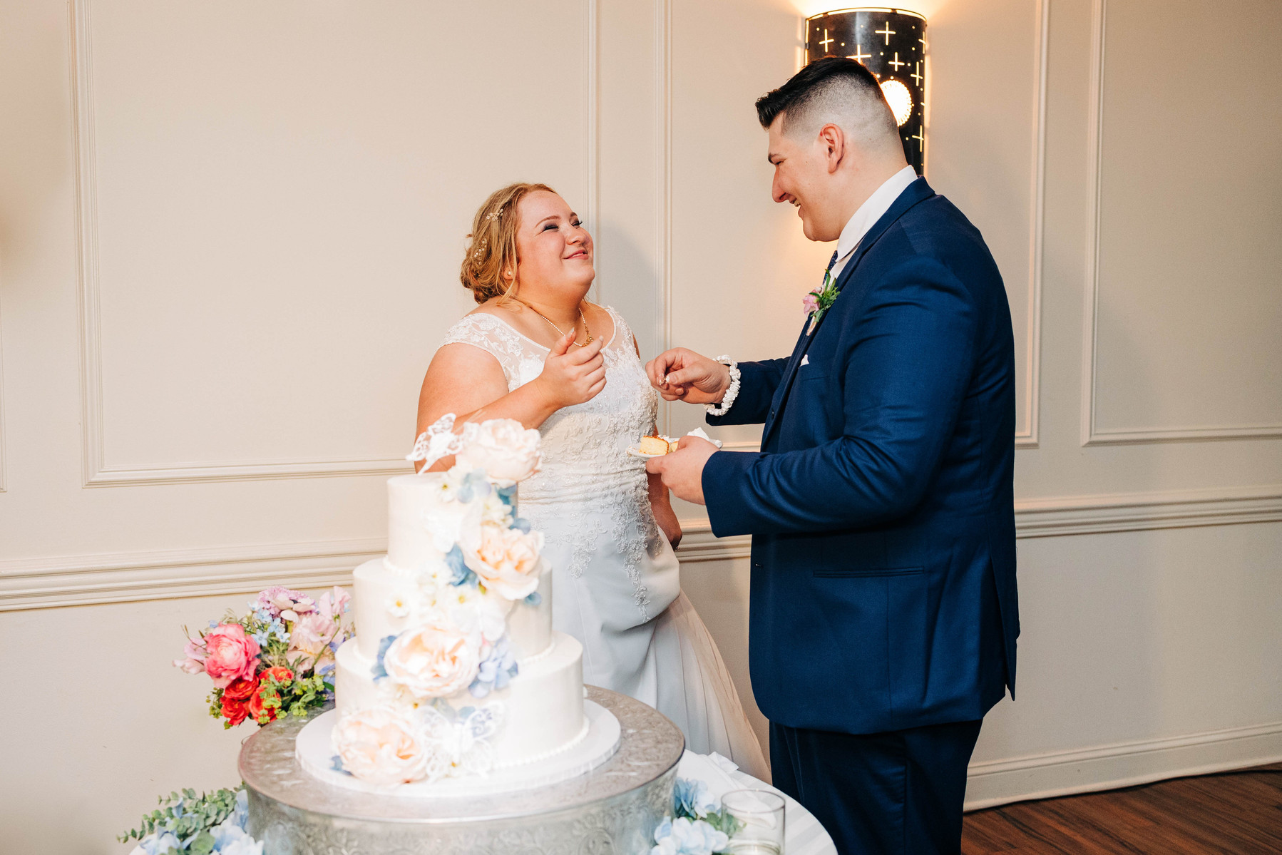 bride and groom cutting their cake during their wedding reception at the farmhouse at people's light theater in malvern pennsylvania