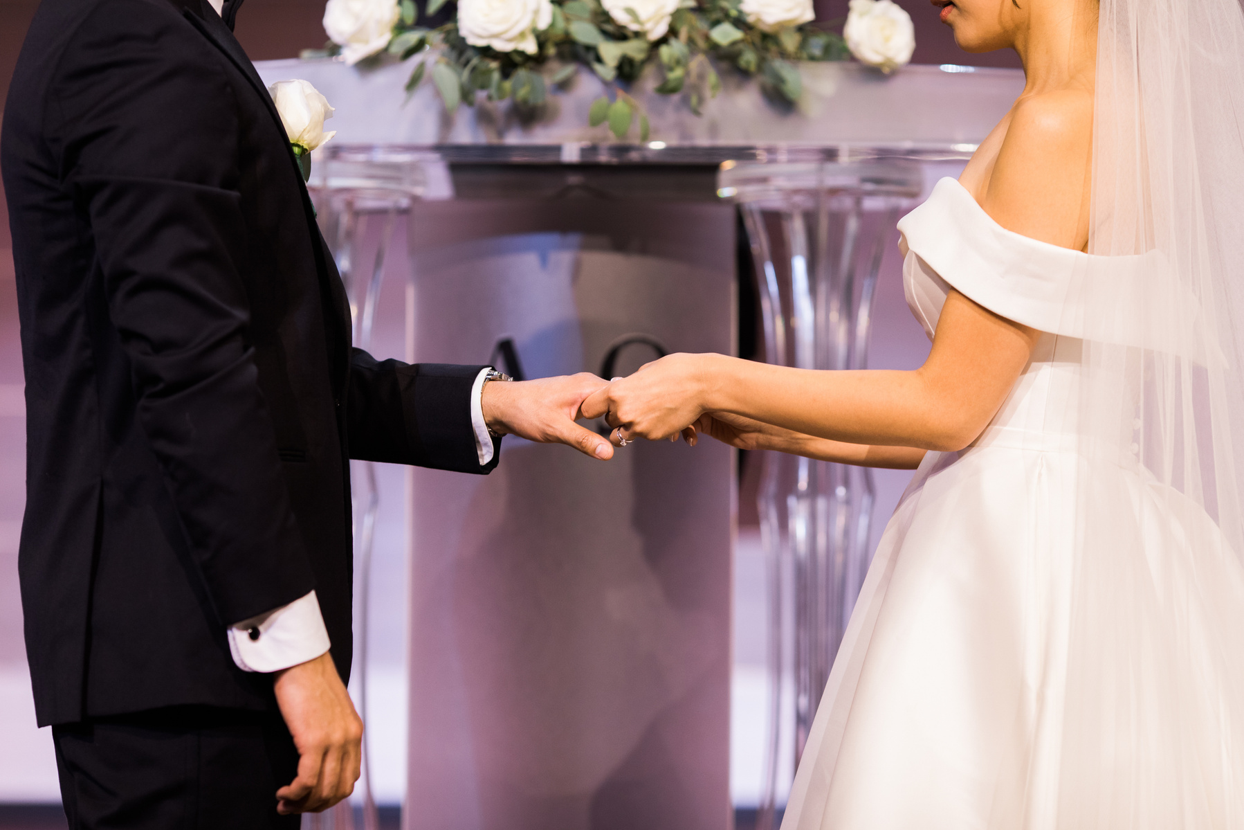 close up photo of bride and groom exchanging rings during wedding ceremony