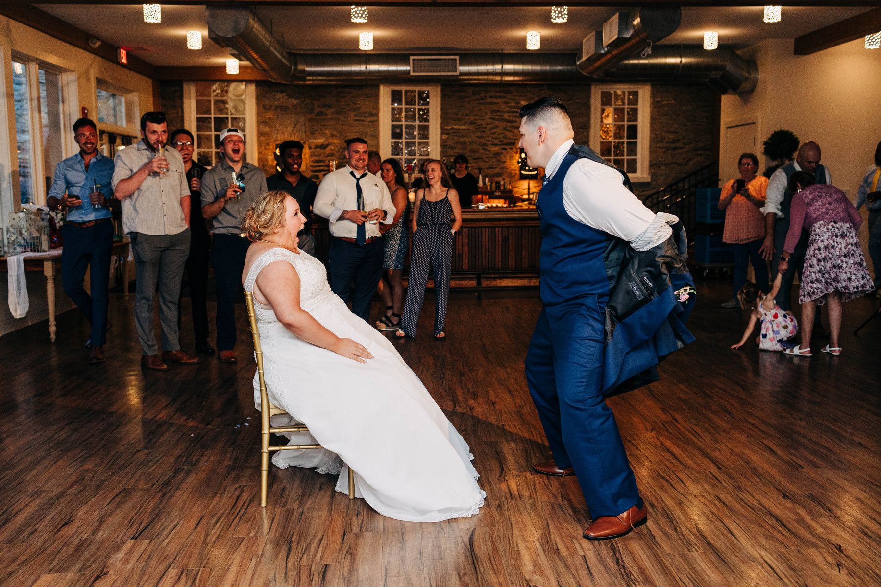 groom dancing with bride during garter toss