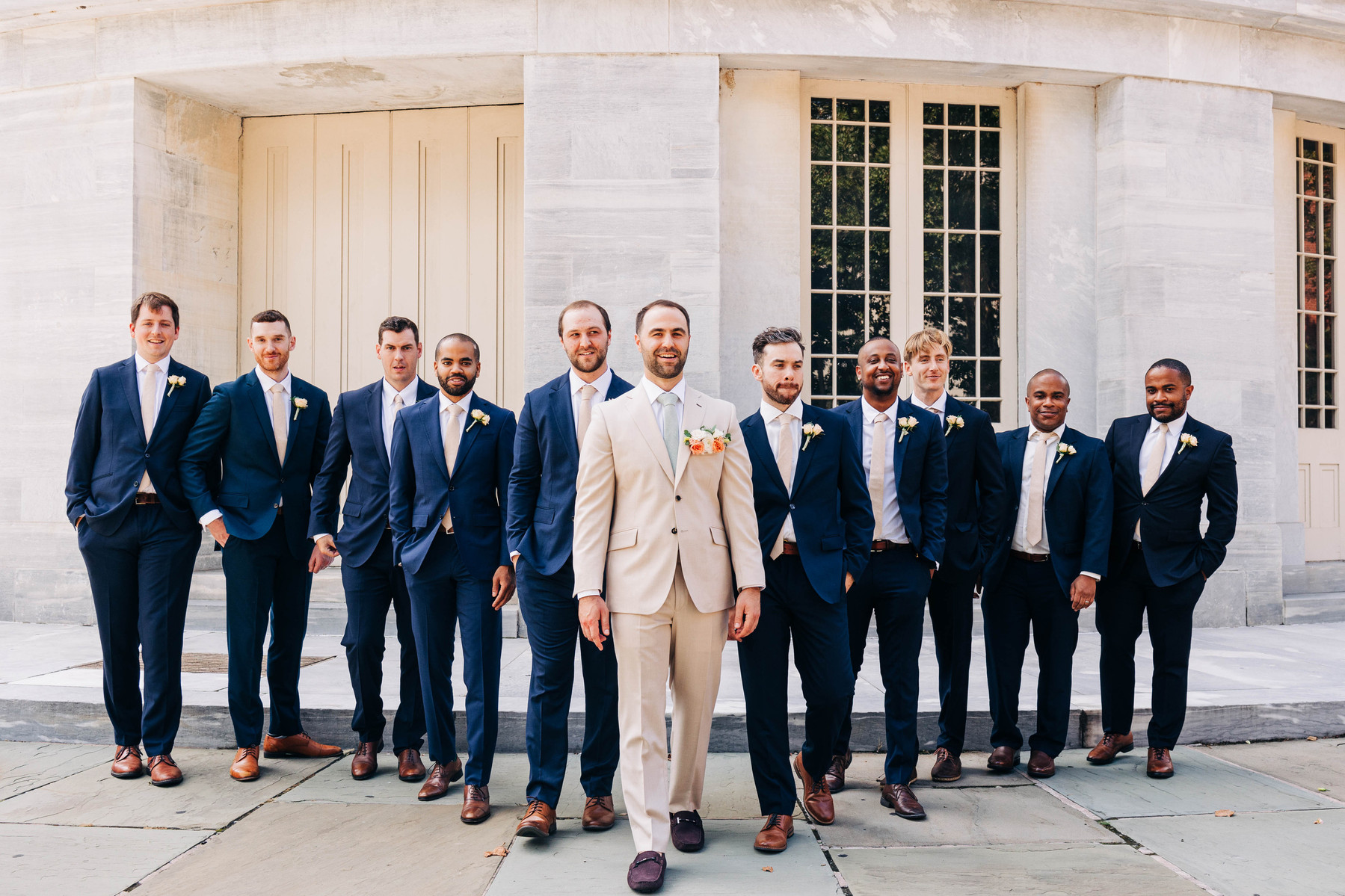 candid group photo of groom walking with groomsmen at the merchant's exchange building in philadelphia