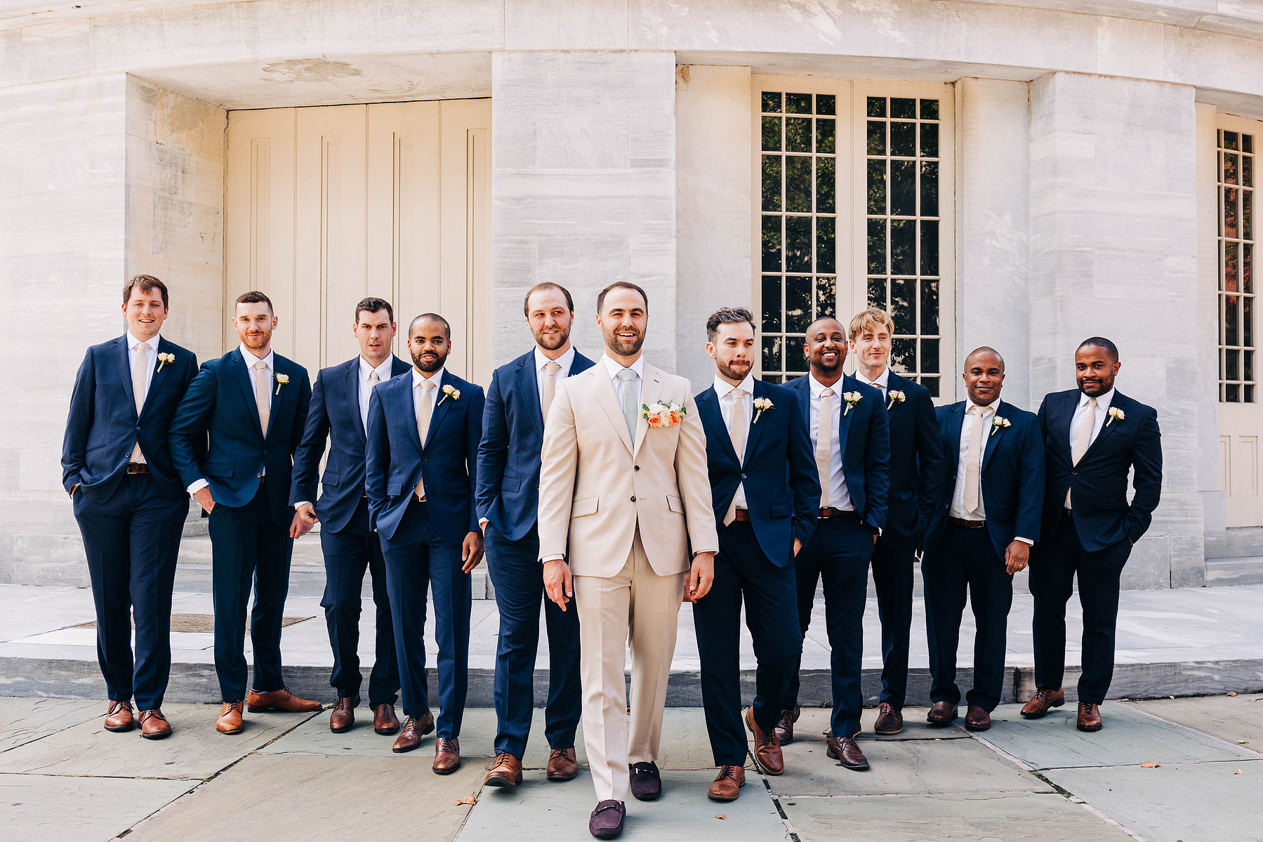 candid group photo of groom walking with groomsmen at the merchant's exchange building in philadelphia