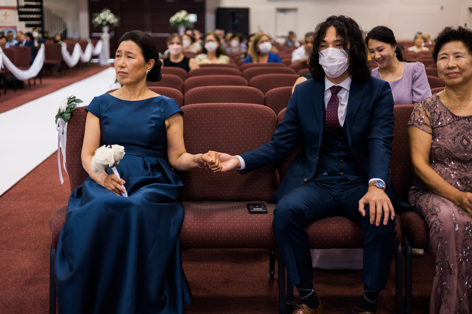 bride's family members hold hands during the wedding ceremony